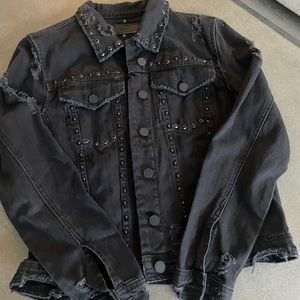 Black distressed denim jacket with black and silver studs.